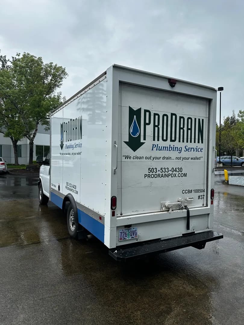 Rear three-quarter view of the completed Pro Drain GMC box truck graphics
