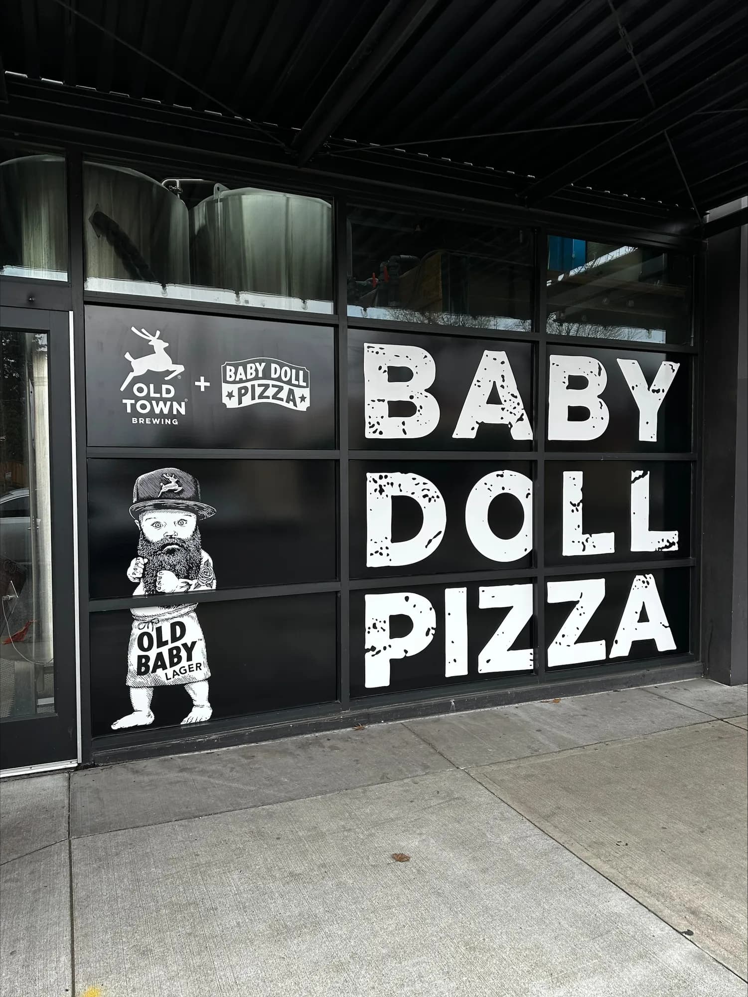 Angled view of the completed Baby Doll Pizza storefront graphics