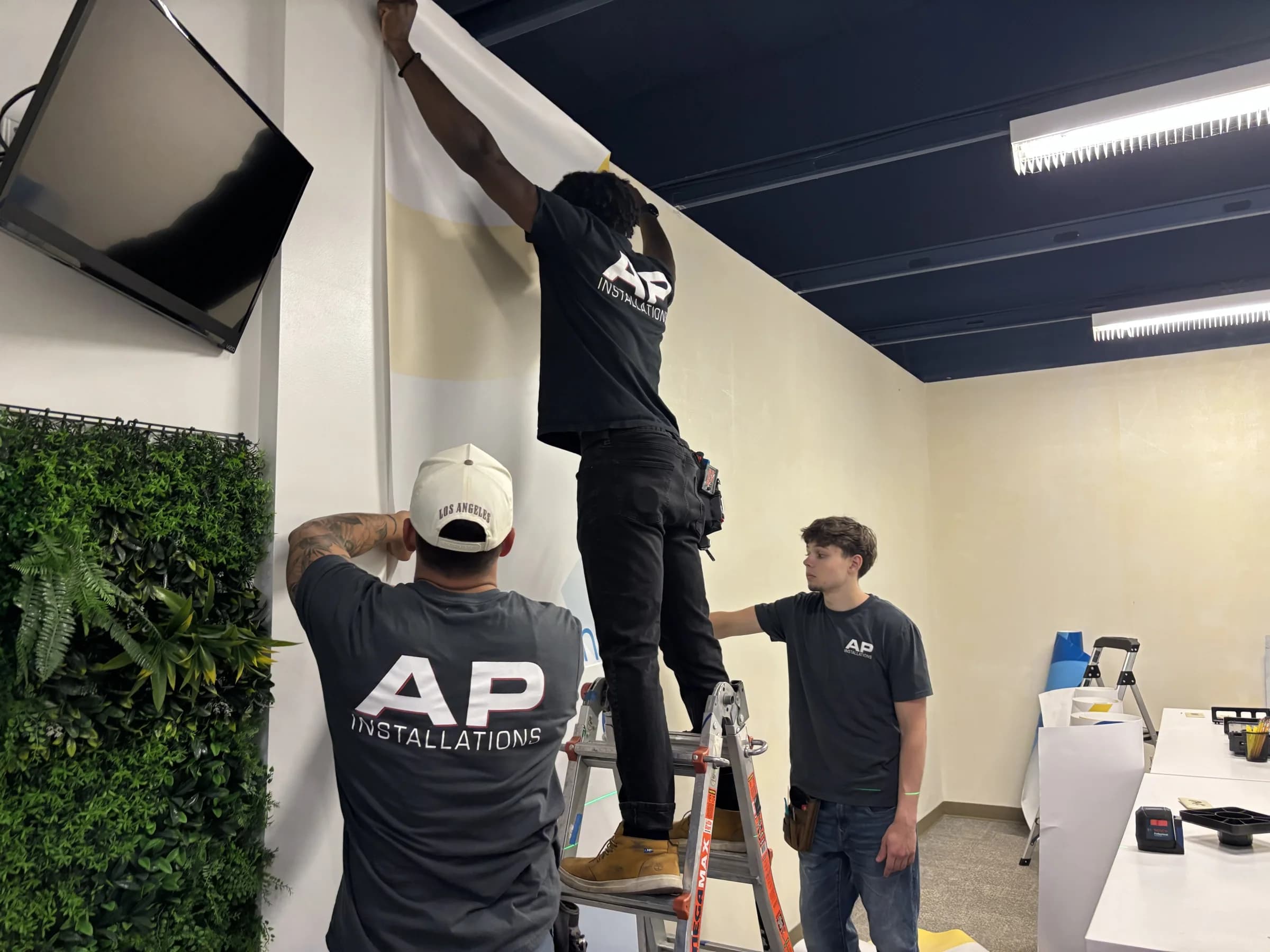 AP Installations crew installing wall graphics at BizTown PDX