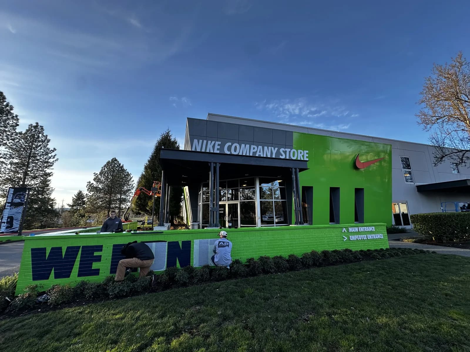 AP crew installing the Seahawks building wrap lettering on the entrance wall