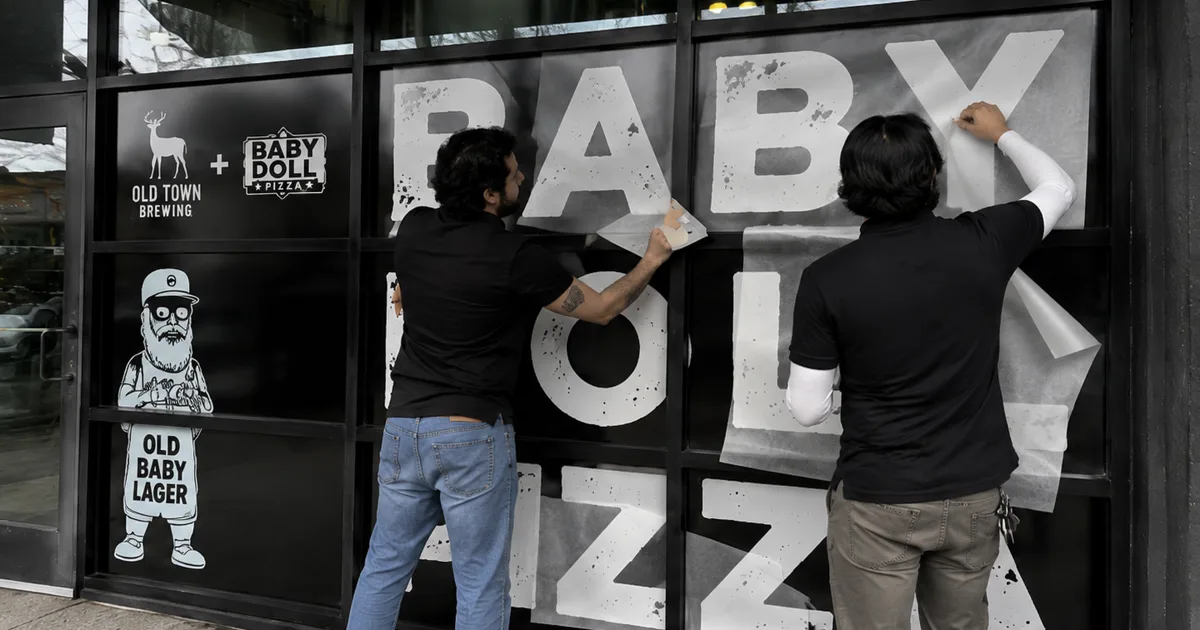Installation team measuring and applying commercial vinyl graphics