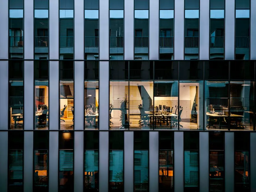 Illuminated office interior viewed through glass building exterior